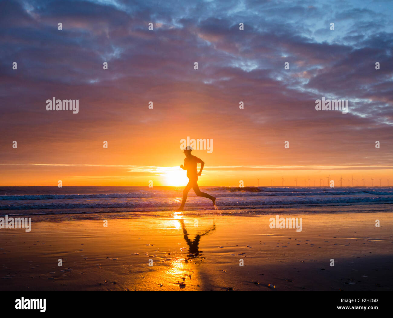 Seaton Carew, UK. 19 Septembre, 2015. Météo : jogger au lever du soleil sur la plage de Seaton Carew sur un glorieux samedi matin sur la côte nord-est de l'Angleterre. Avec haute pression sur le Royaume-Uni, le samedi est appelée à être ensoleillé avec des températures dans le milieu à des adolescents pour une grande partie de l'UK. Credit : Alan Dawson News/Alamy Live News Banque D'Images