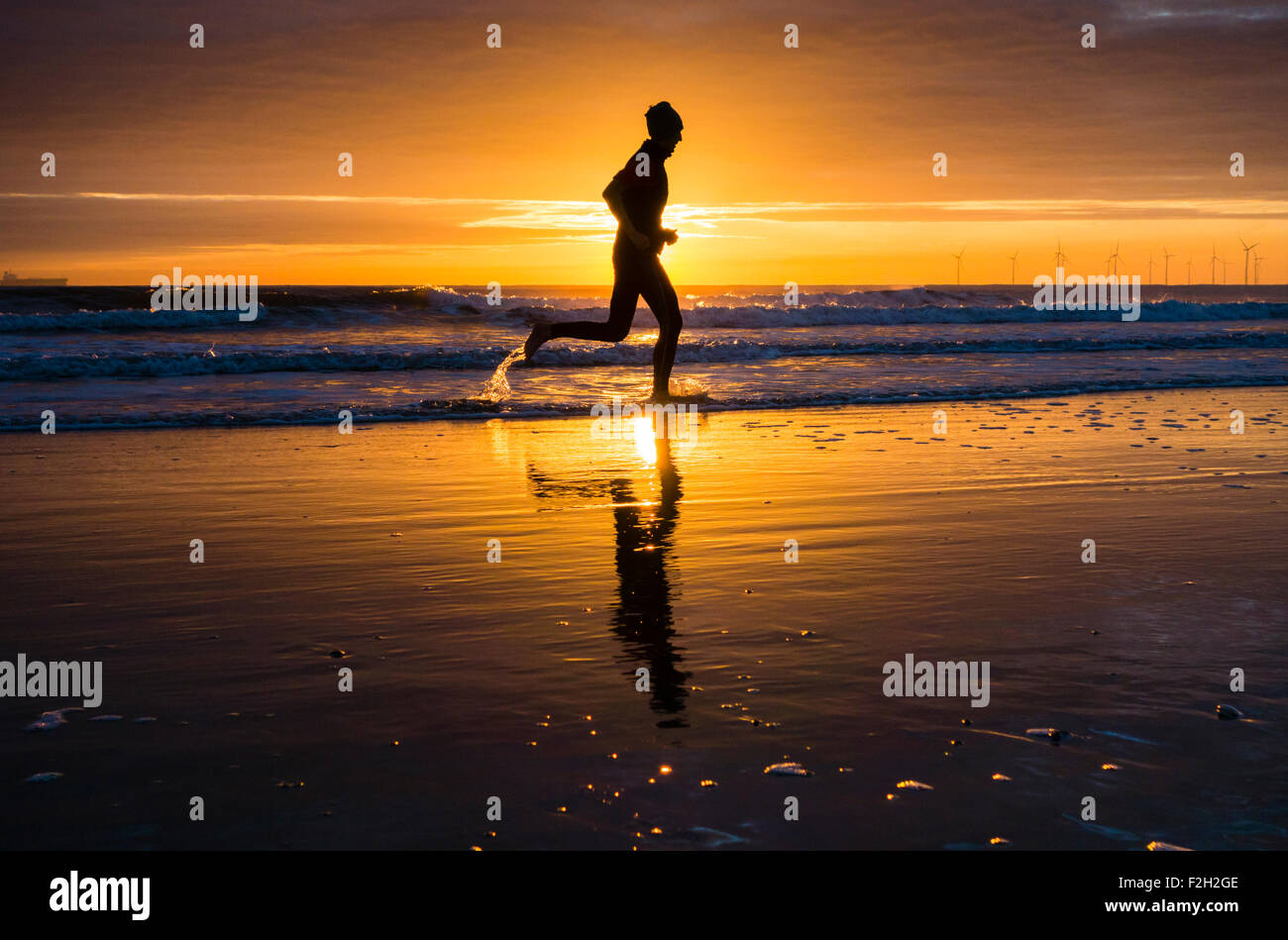 Seaton Carew, UK. 19 Septembre, 2015. Météo : jogger au lever du soleil sur la plage de Seaton Carew sur un glorieux samedi matin sur la côte nord-est de l'Angleterre. Avec haute pression sur le Royaume-Uni, le samedi est appelée à être ensoleillé avec des températures dans le milieu à des adolescents pour une grande partie de l'UK. Credit : Alan Dawson News/Alamy Live News Banque D'Images