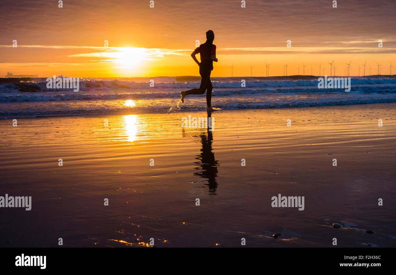 Seaton Carew, UK. 19 Septembre, 2015. Météo : jogger au lever du soleil sur la plage de Seaton Carew sur un glorieux samedi matin sur la côte nord-est de l'Angleterre. Avec haute pression sur le Royaume-Uni, le samedi est appelée à être ensoleillé avec des températures dans le milieu à des adolescents pour une grande partie de l'UK. Credit : Alan Dawson News/Alamy Live News Banque D'Images