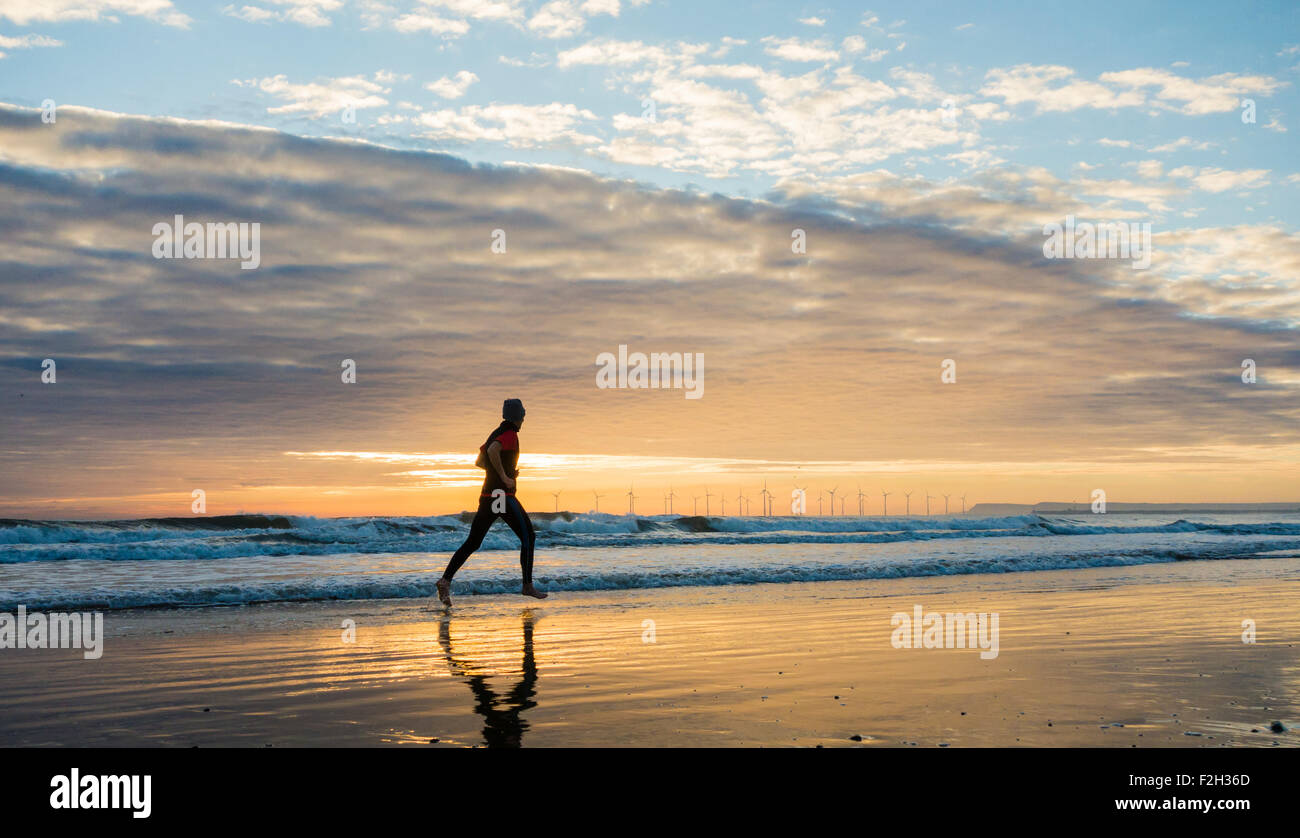 Seaton Carew, UK. 19 Septembre, 2015. Météo : jogger au lever du soleil sur la plage de Seaton Carew sur un glorieux samedi matin sur la côte nord-est de l'Angleterre. Avec haute pression sur le Royaume-Uni, le samedi est appelée à être ensoleillé avec des températures dans le milieu à des adolescents pour une grande partie de l'UK. Credit : Alan Dawson News/Alamy Live News Banque D'Images