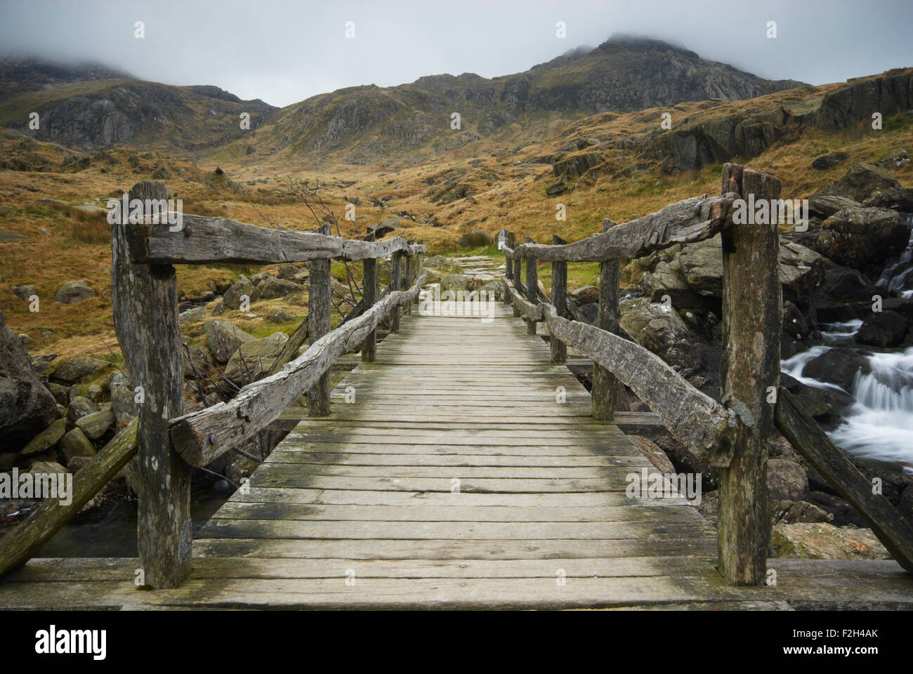 Vue de la passerelle qui traverse une rivière sur le sentier qui mène au MCG Idwal dans le parc national de Snowdonia, Pays de Galles, Royaume-Uni Banque D'Images