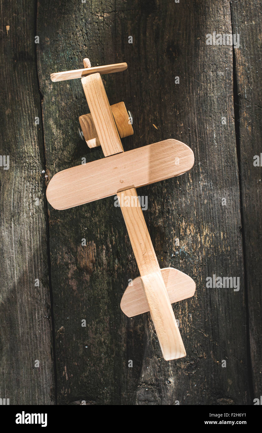 Avion en bois Vintage sur planche de bois. Soleil à travers la fenêtre Banque D'Images