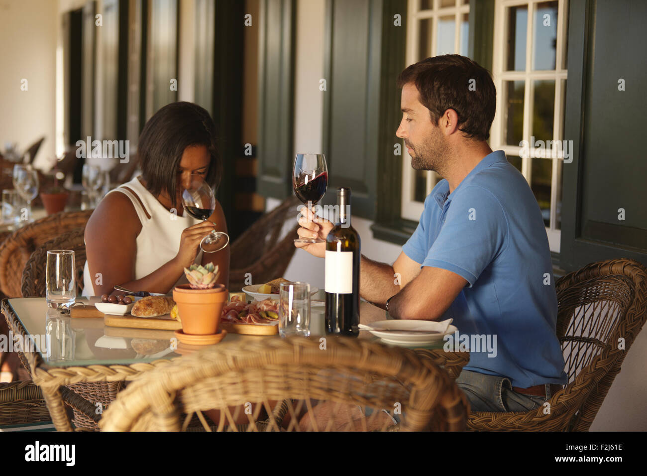 Young couple sitting at table vin rouge dégustation au restaurant de l'établissement vinicole. Couple à la dégustation de vins avec woman smelling vin. Banque D'Images