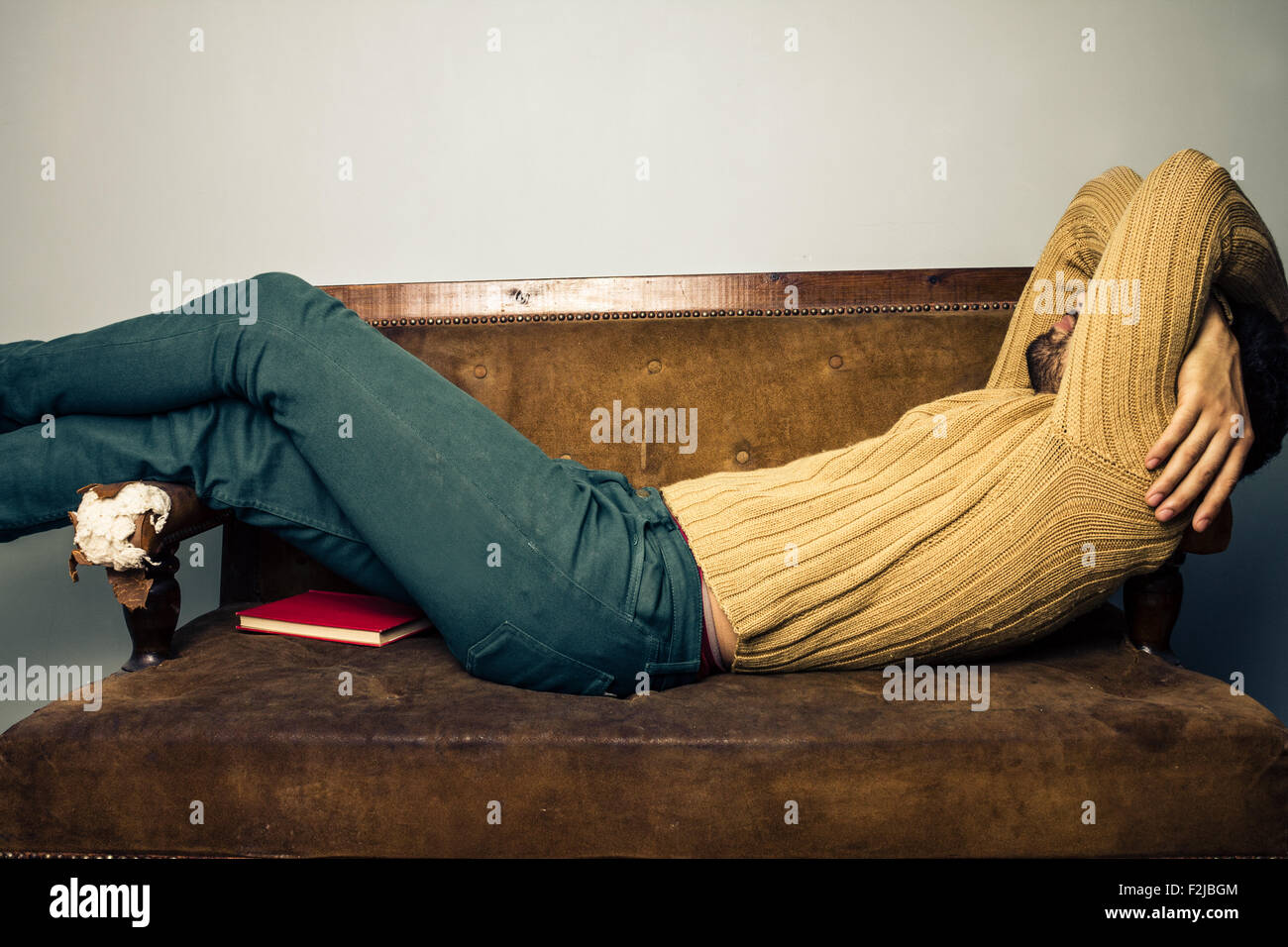 Jeune homme endormi sur le canapé Banque D'Images