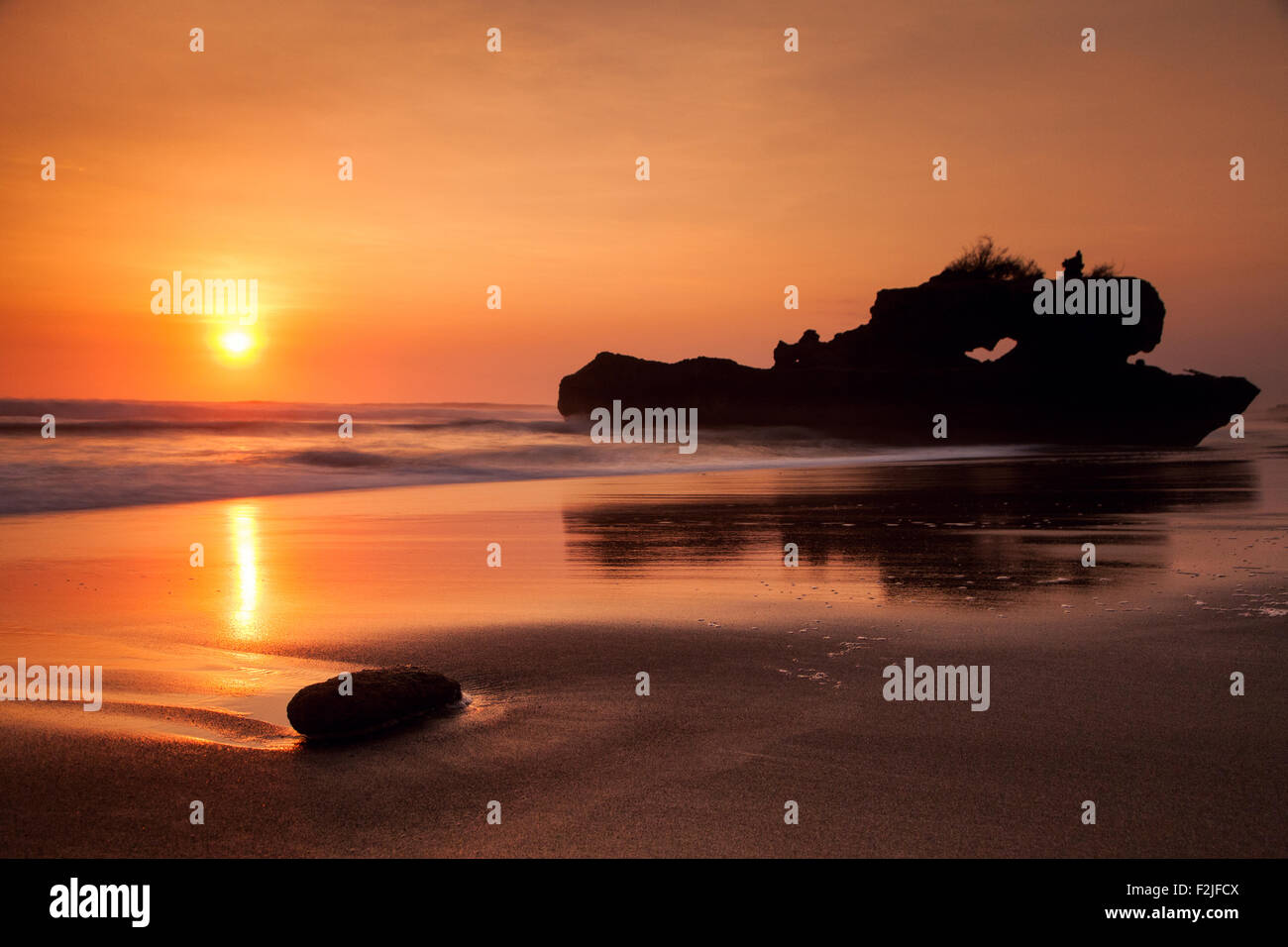 Magnifique coucher de soleil à Yeh Gangga rocher naturel formé sur une plage à Bali Banque D'Images