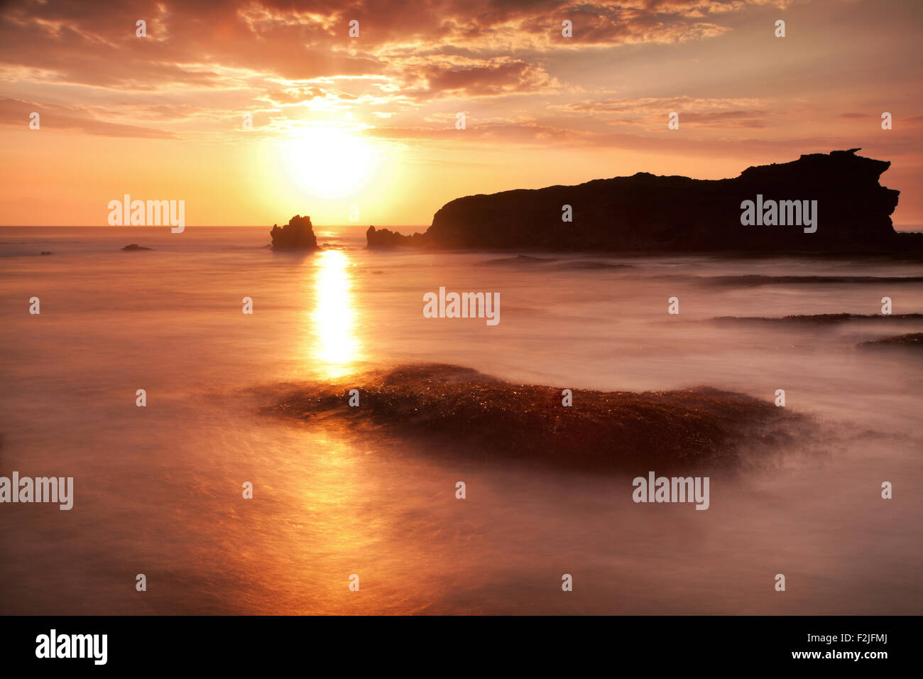 Magnifique coucher de soleil sur la côte rocheuse de Bali, Indonésie. silhouetté sea stacks aide créer une image surréaliste avec des effets photo longue exposition ajoutée Banque D'Images