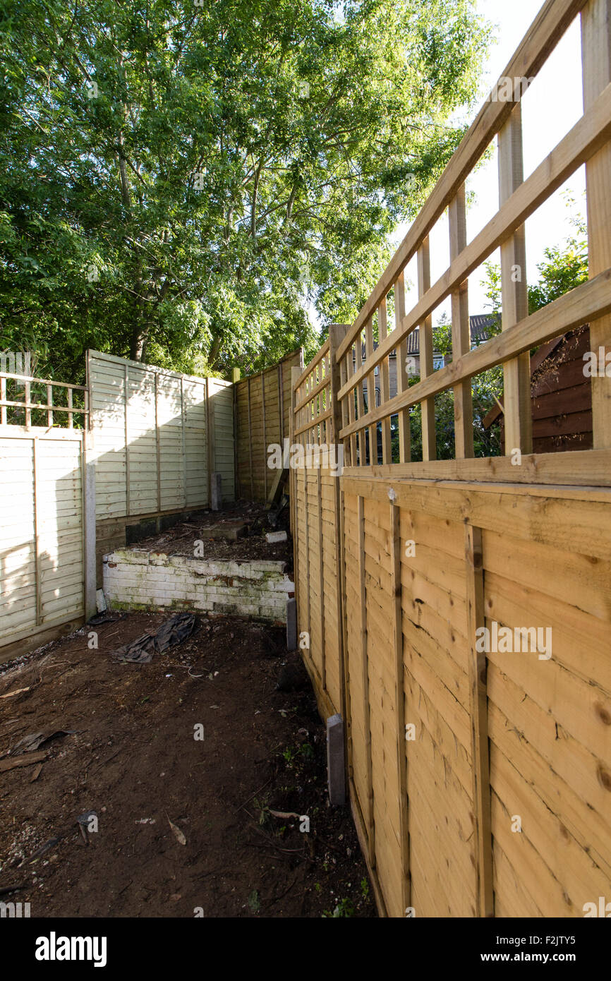 Une nouvelle clôture dans un jardin de banlieue Banque D'Images