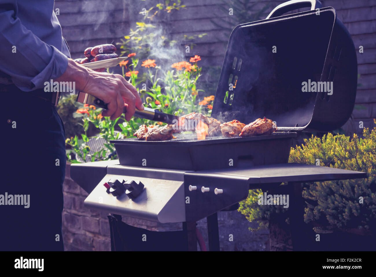 L'extérieur barbecue cuisson Senior man Banque D'Images