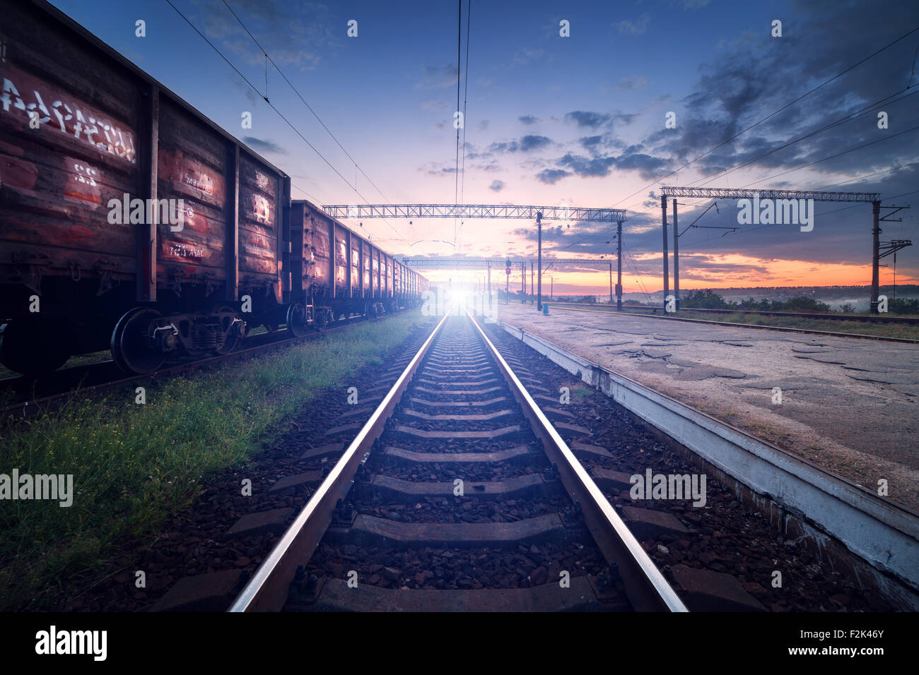 Plate-forme du train de fret au coucher du soleil. Railroad en Ukraine. La gare ferroviaire. Banque D'Images