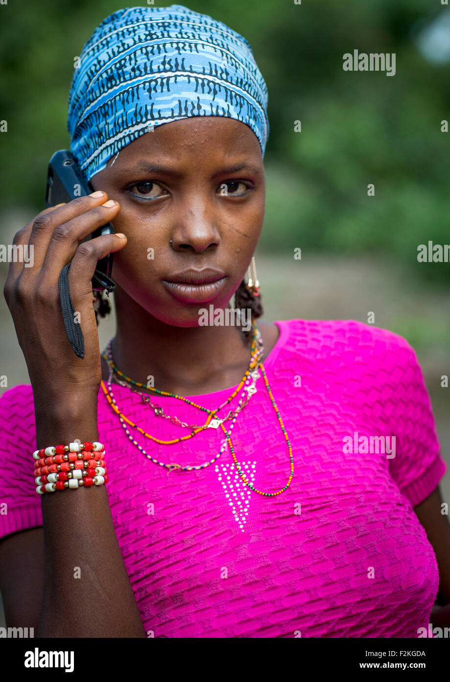 Le Bénin, en Afrique de l'Ouest, Gossoue, une belle femme tribu peul peul tatouée pause avec son téléphone portable Banque D'Images
