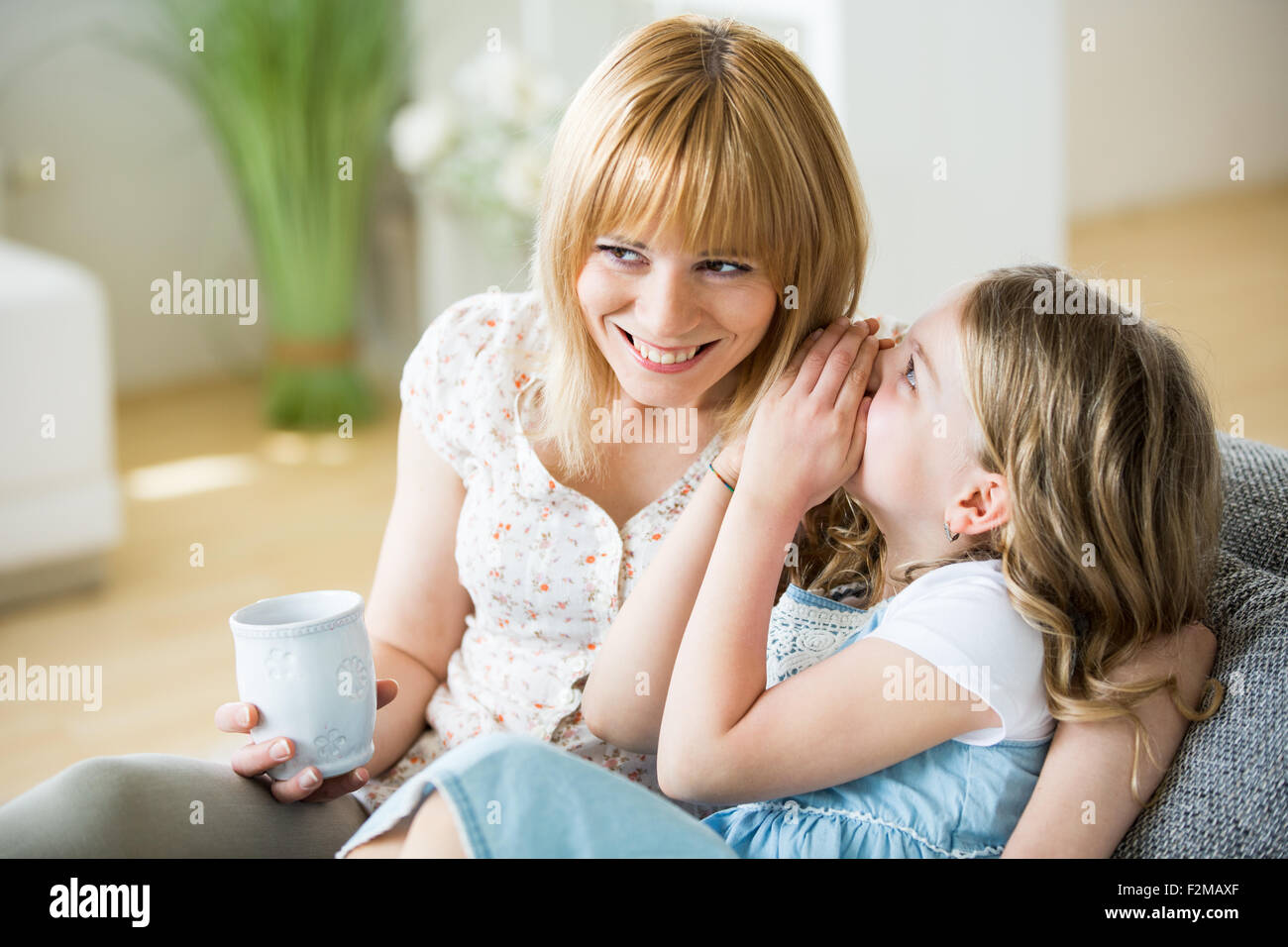 Mère et fille assis sur table avec les verres Banque D'Images