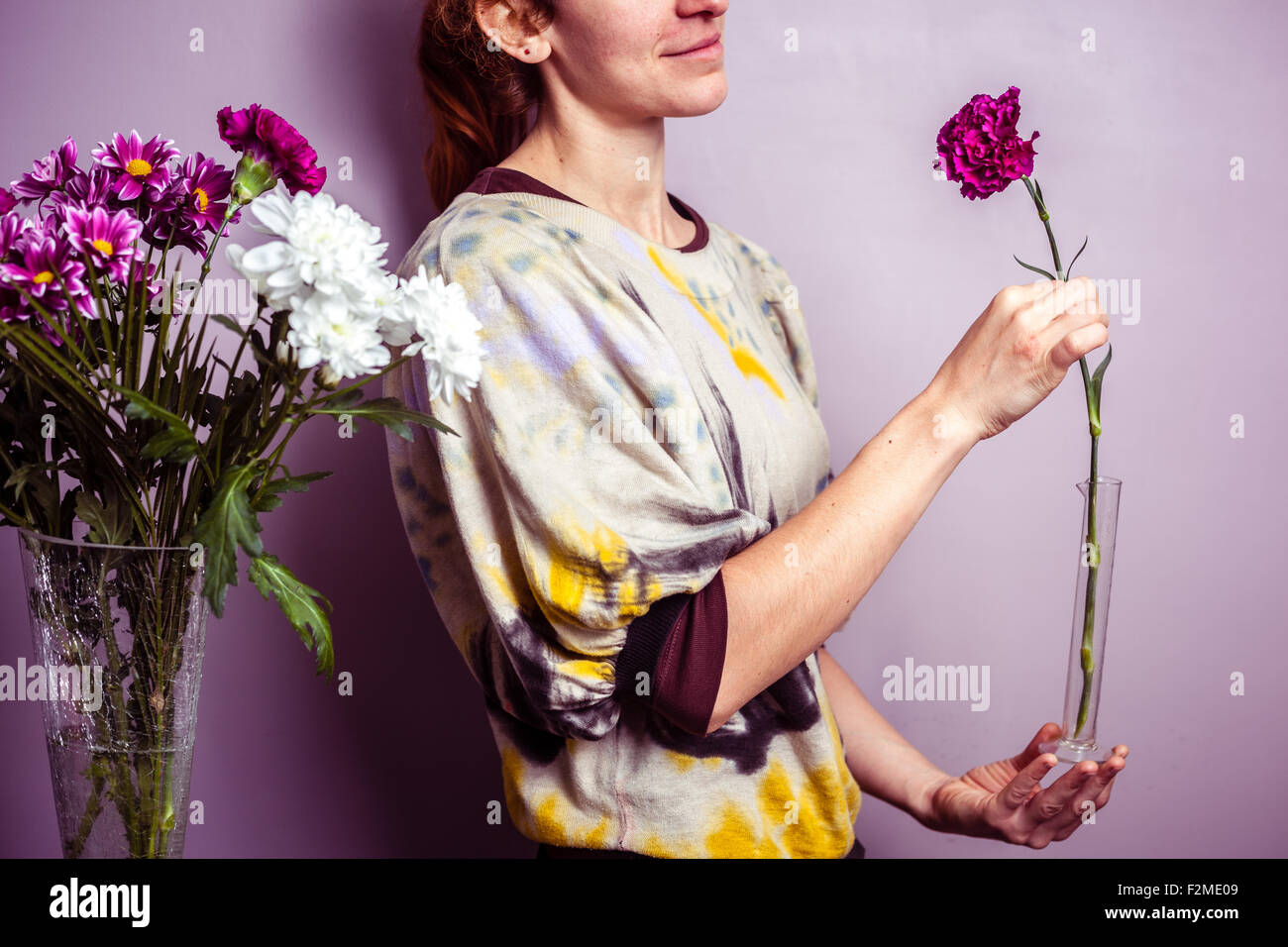 Femme mettant des fleurs dans un vase Banque de photographies et d