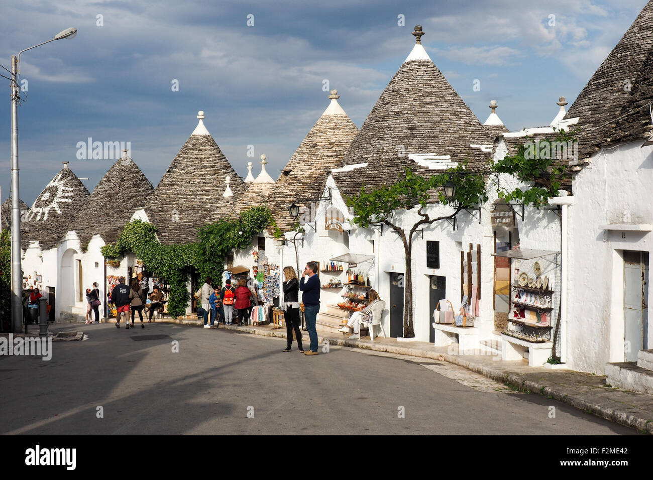 Les touristes se promenant dans une rue de Trulli dans le quartier de Monti à Alberobello Banque D'Images
