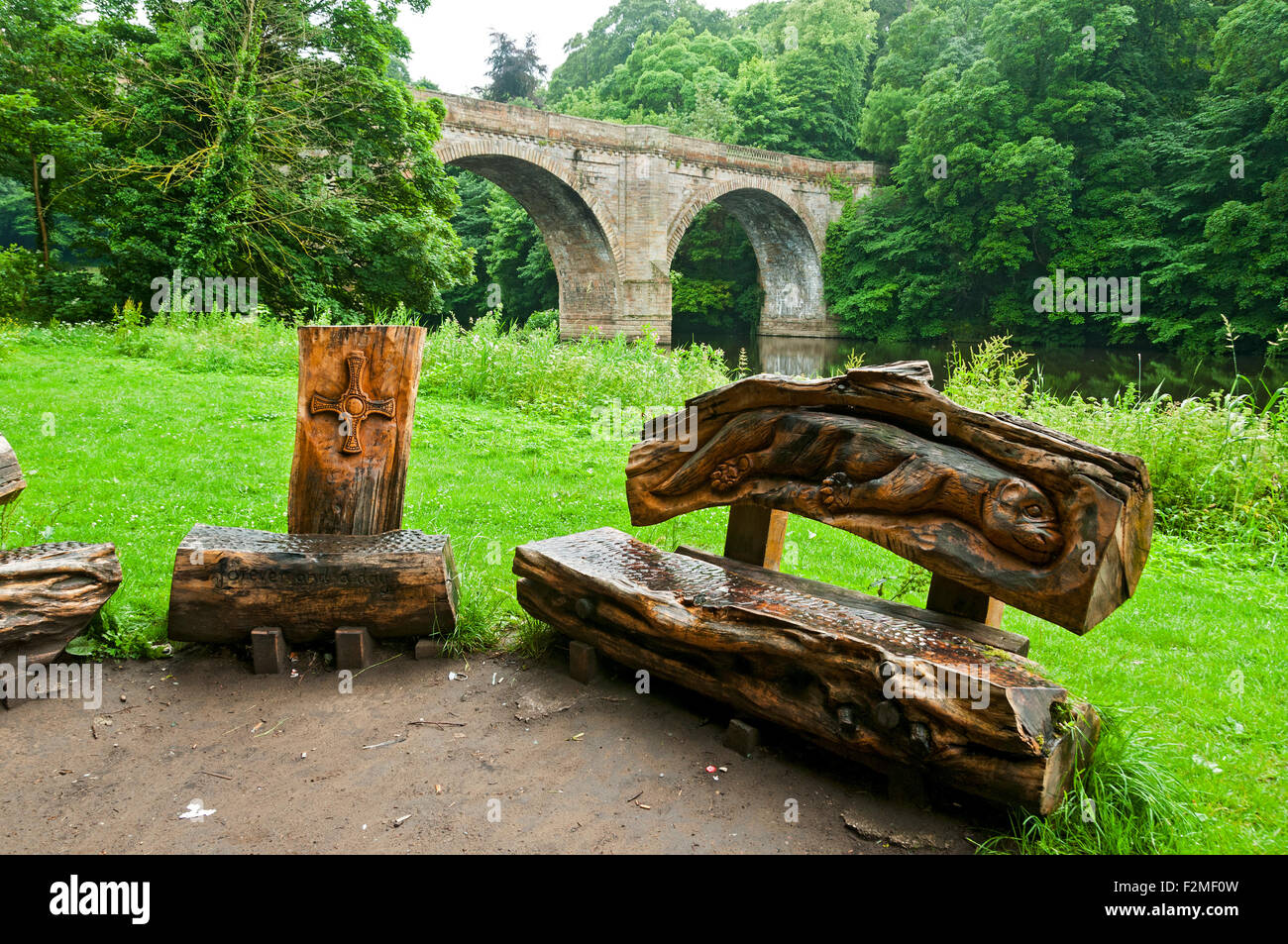 Sièges en bois sculpté sur la rivière Wear chemin Riverside Prebends' Bridge, près de la ville de Durham, England, UK. Banque D'Images