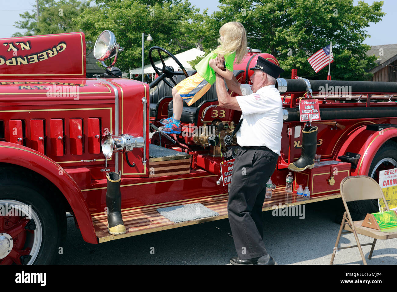 Pompier ancien enfant de levage sur feu antique à Greenport moteur Long Island New York Banque D'Images