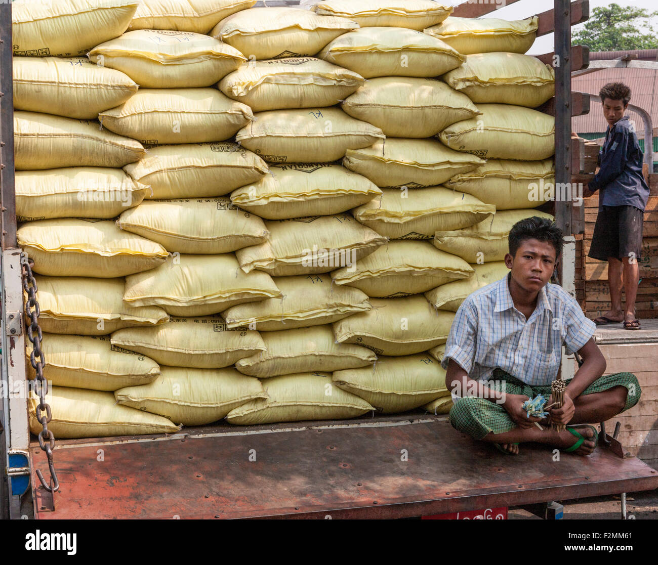 Camion plein de sacs de riz au Port de Yangon avec débardeur assis sur hayon holding tally sticks Banque D'Images