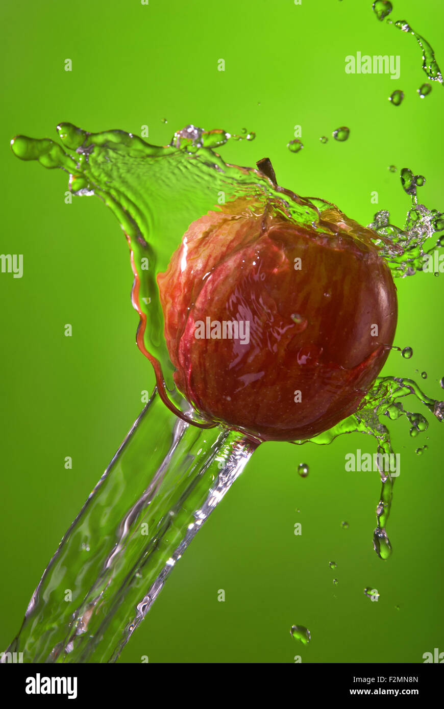 Style de vie sain de l'eau splash apple sur fond vert. Idéal pour une campagne sur la nutrition ou sur votre site web. Banque D'Images