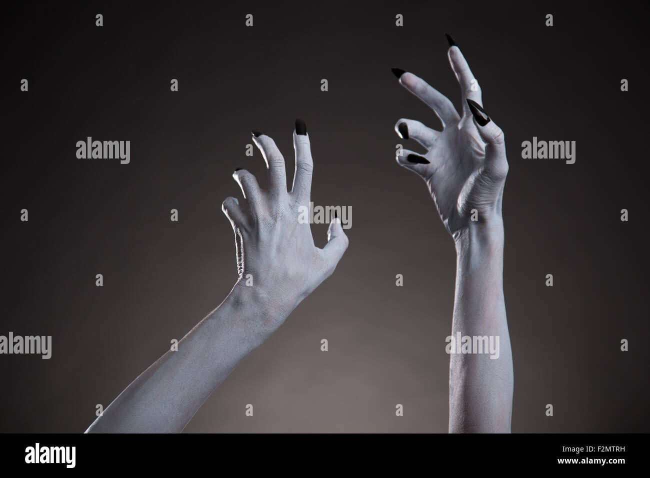 Spooky Halloween blanches mains avec des ongles noirs s'étendant jusqu', body art Banque D'Images