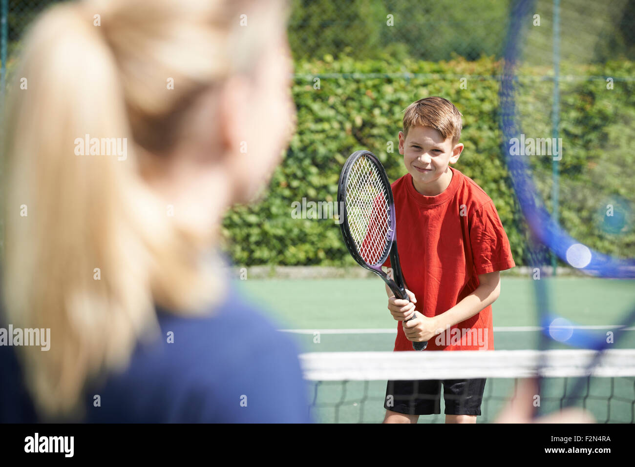 Entraîneur de tennis féminin donnant Leçon pour garçon Banque D'Images