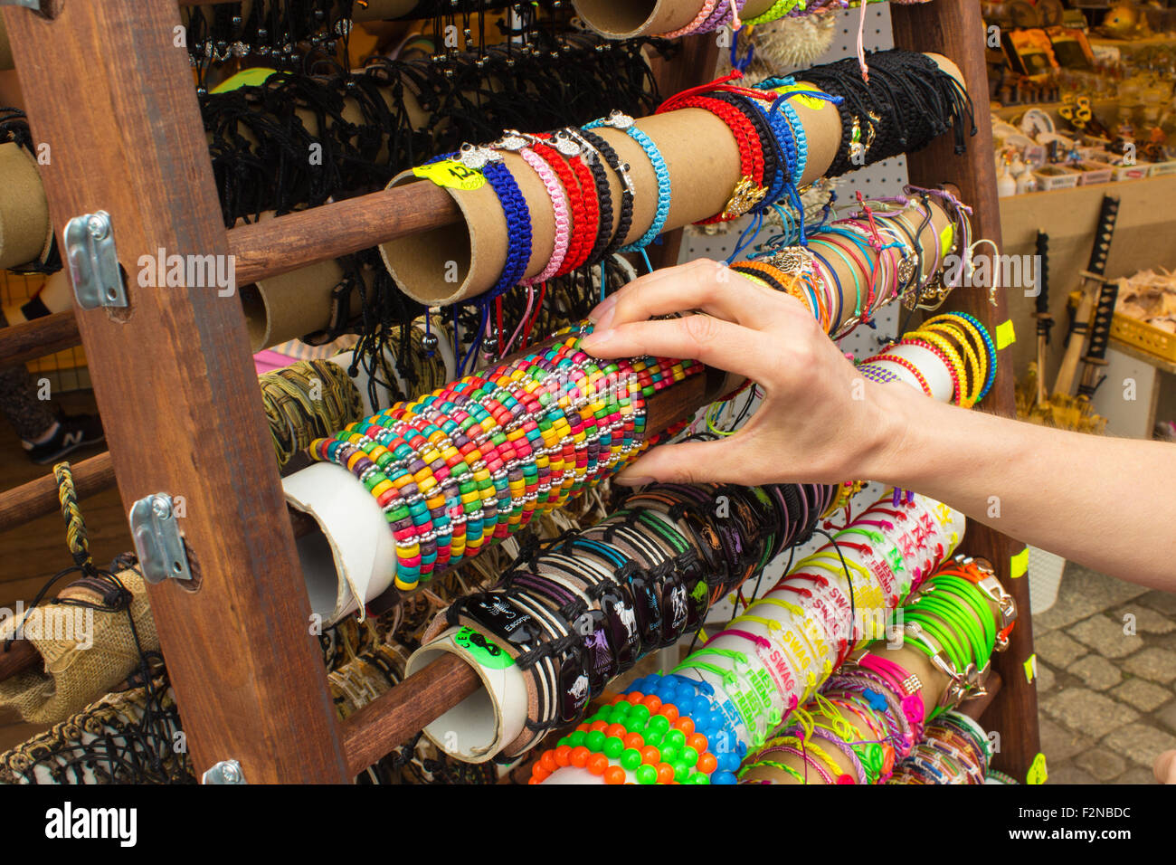 Main de femme avec des bracelets colorés, des bijoux et accessoires femme sur stand au bazar Banque D'Images