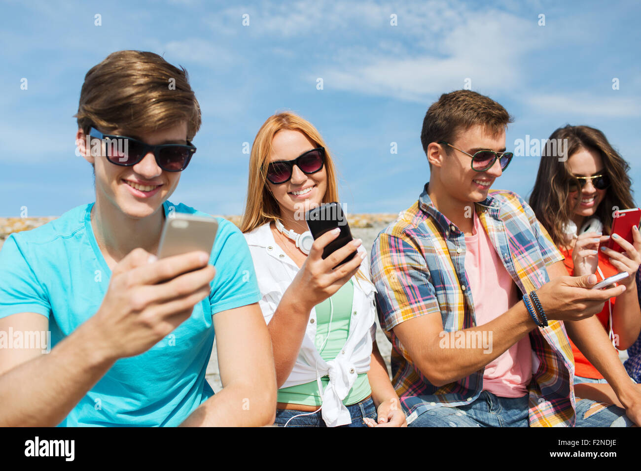 Groupe d'amis heureux avec les smartphones en plein air Banque D'Images