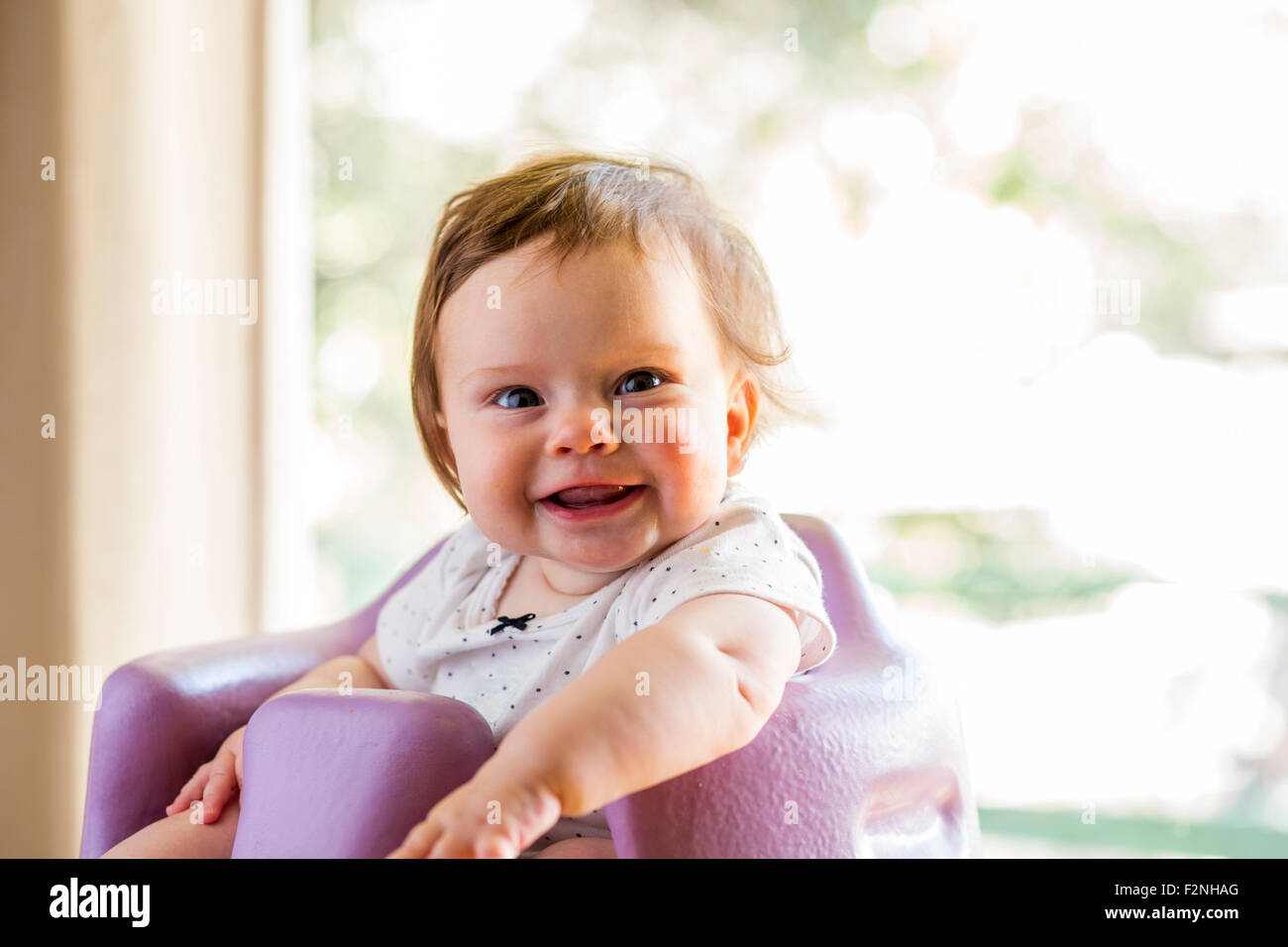 Caucasian baby girl sitting in chaise haute Banque D'Images
