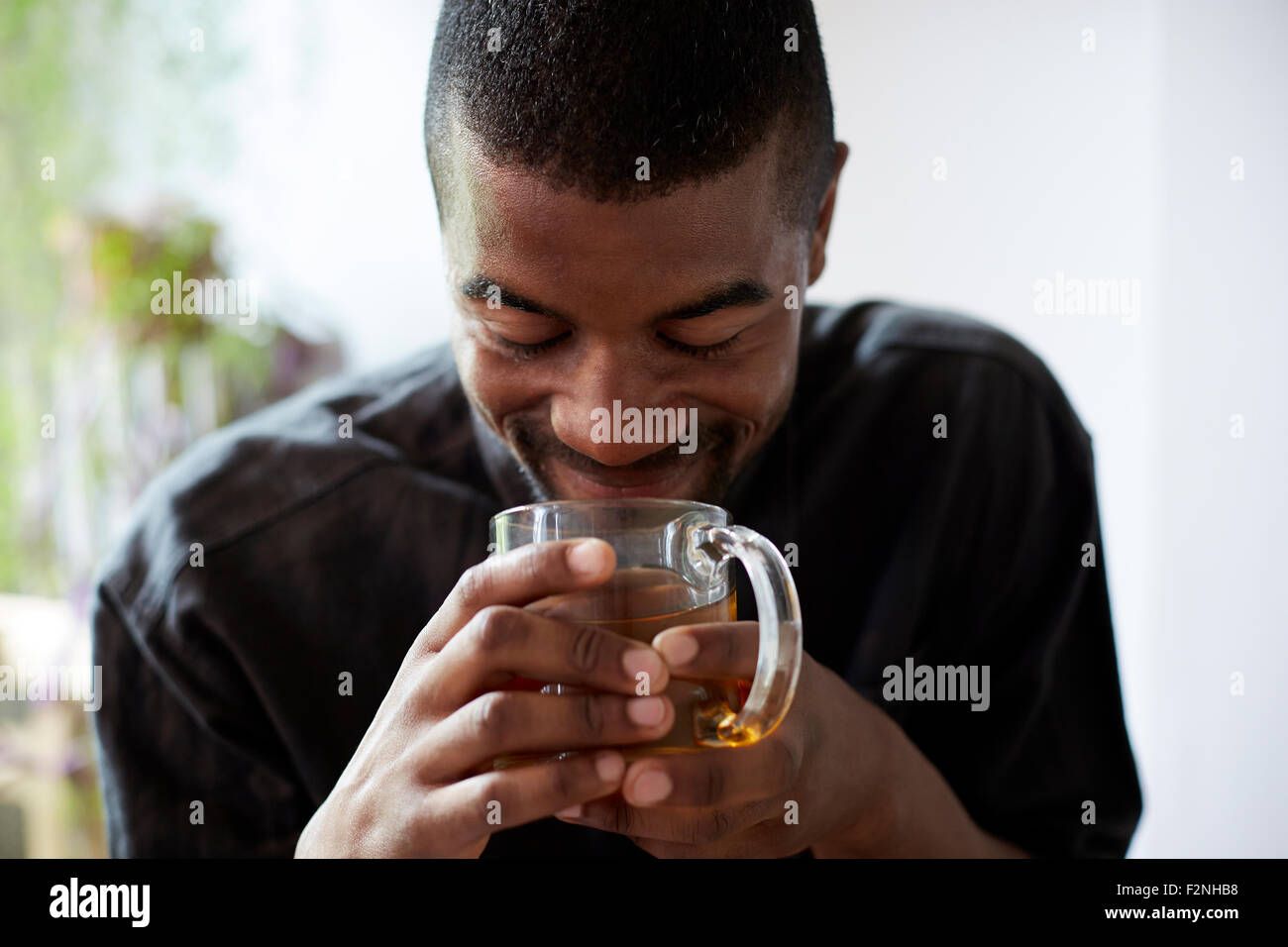Black man drinking cup of tea Banque D'Images