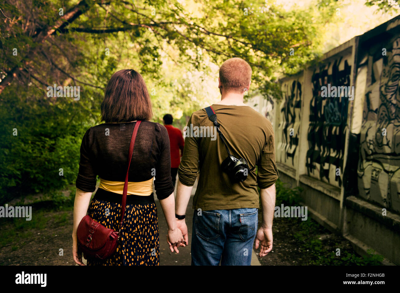 Young couple holding hands in urban park Banque D'Images