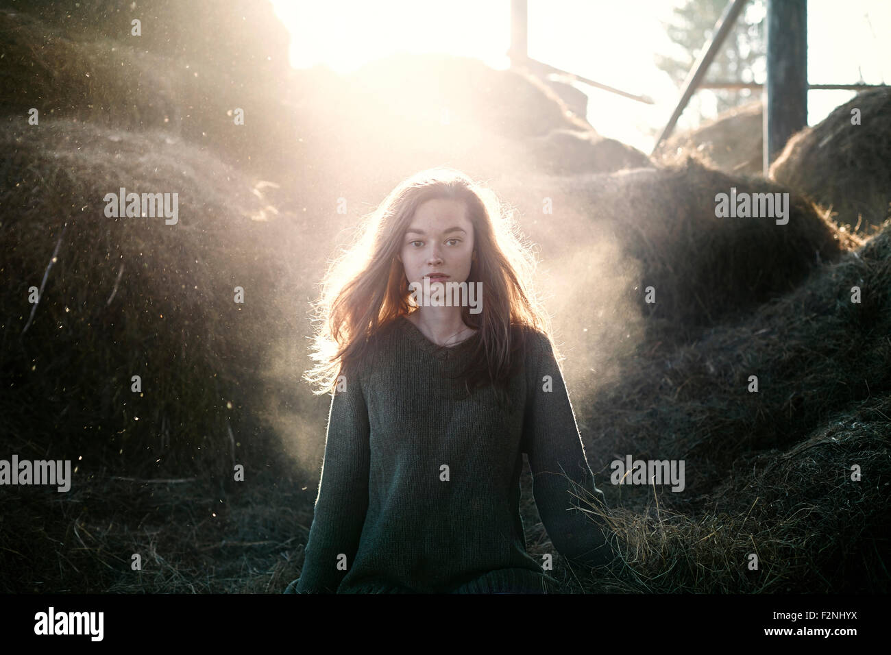 Caucasian woman walking debout près de bottes de foin à la ferme Banque D'Images