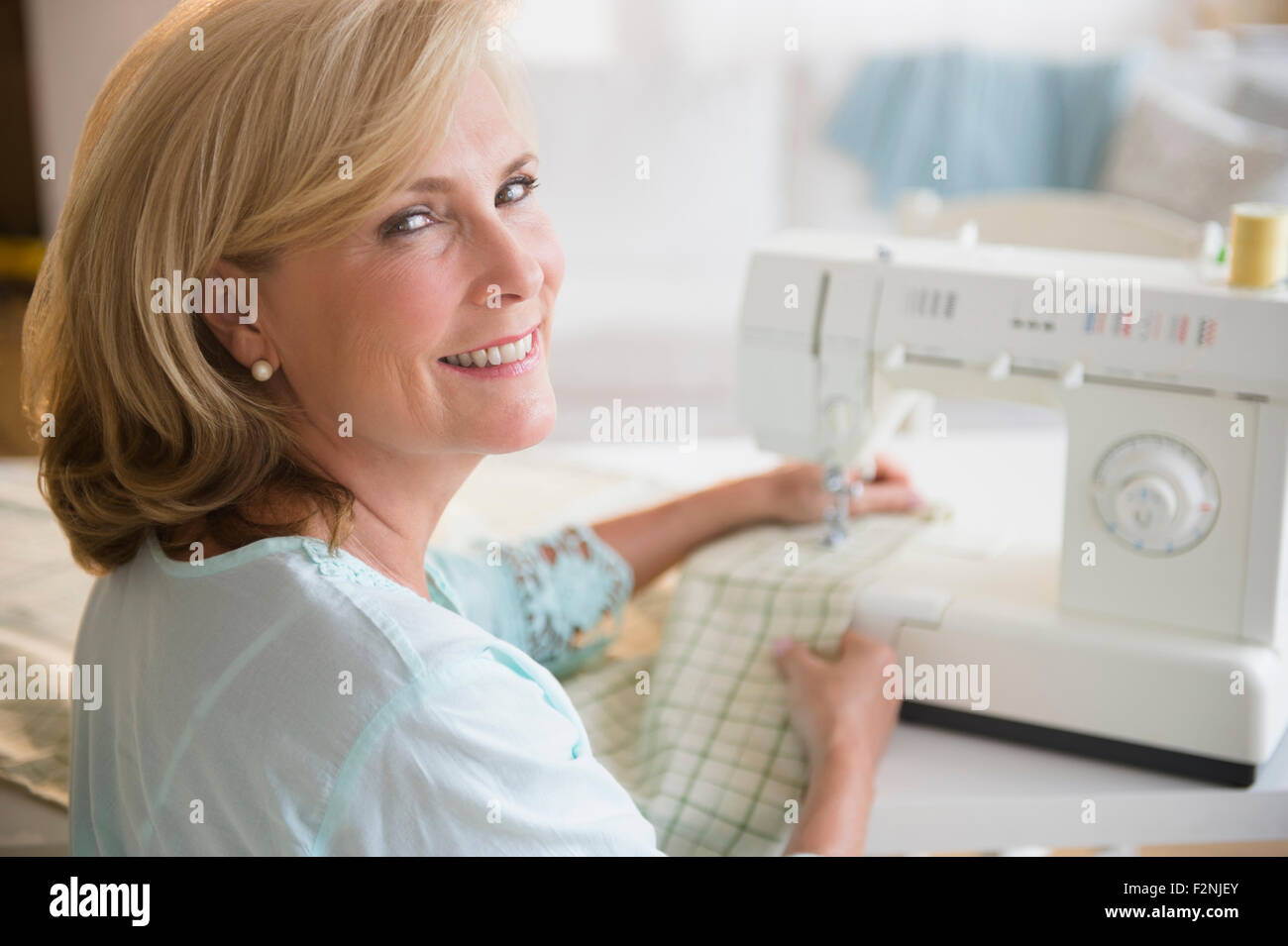 Caucasian woman using sewing machine Banque D'Images