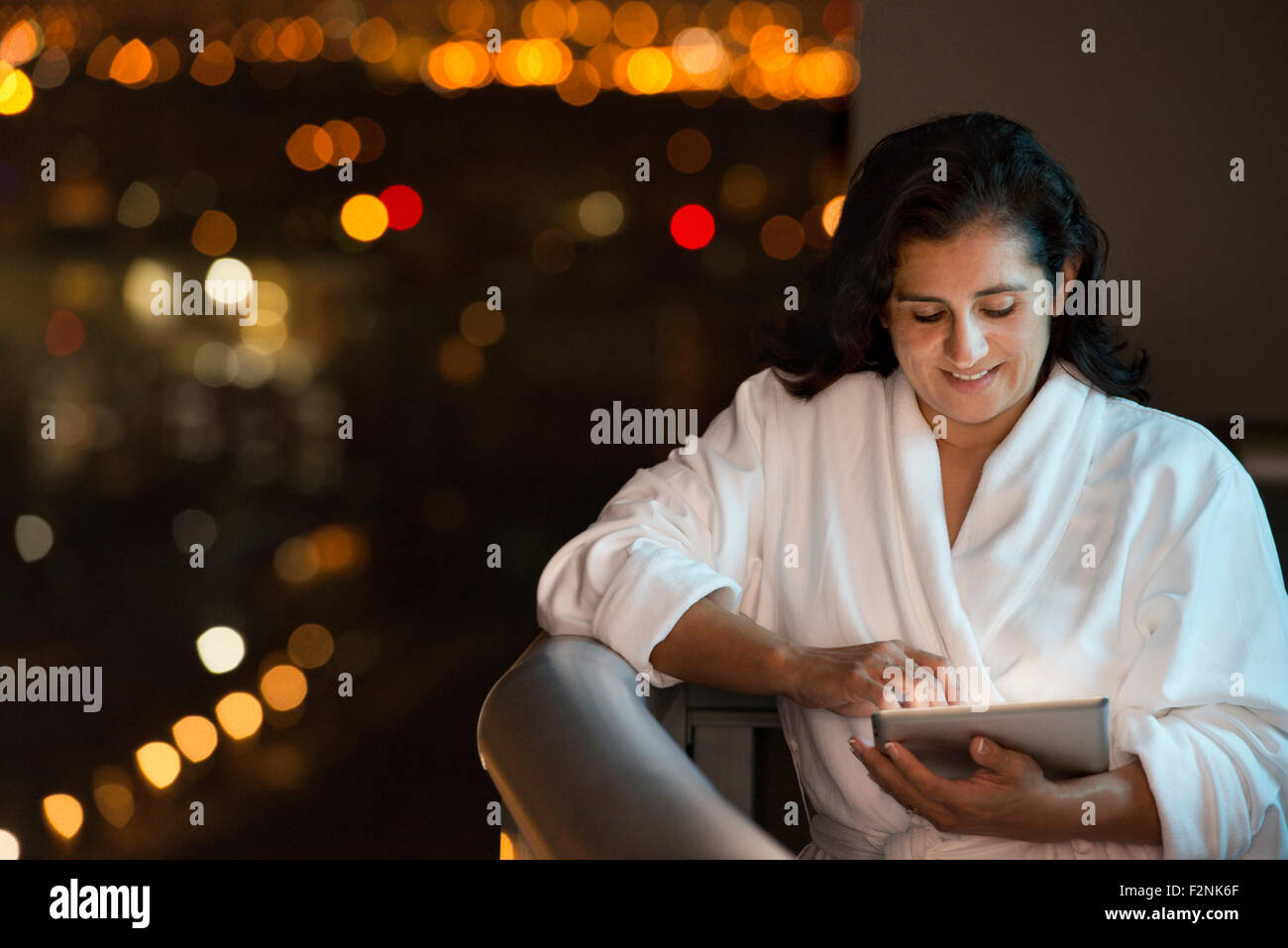 Hispanic woman using digital tablet sur balcon de l'hôtel Banque D'Images