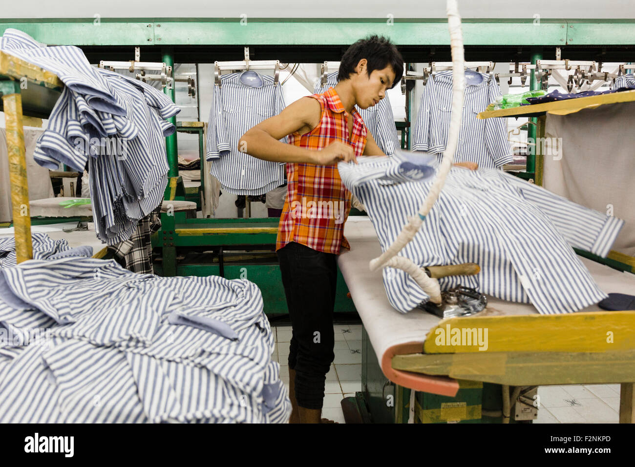 Travailleur asiatique chemise repassage en garment factory Banque D'Images