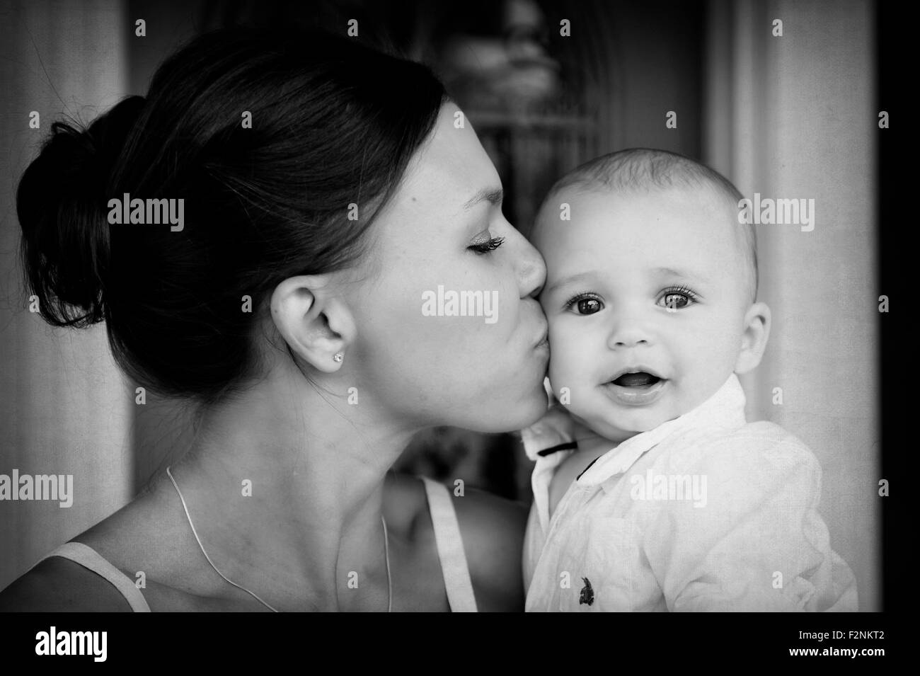 Close up mixed race mother kissing baby son Banque D'Images
