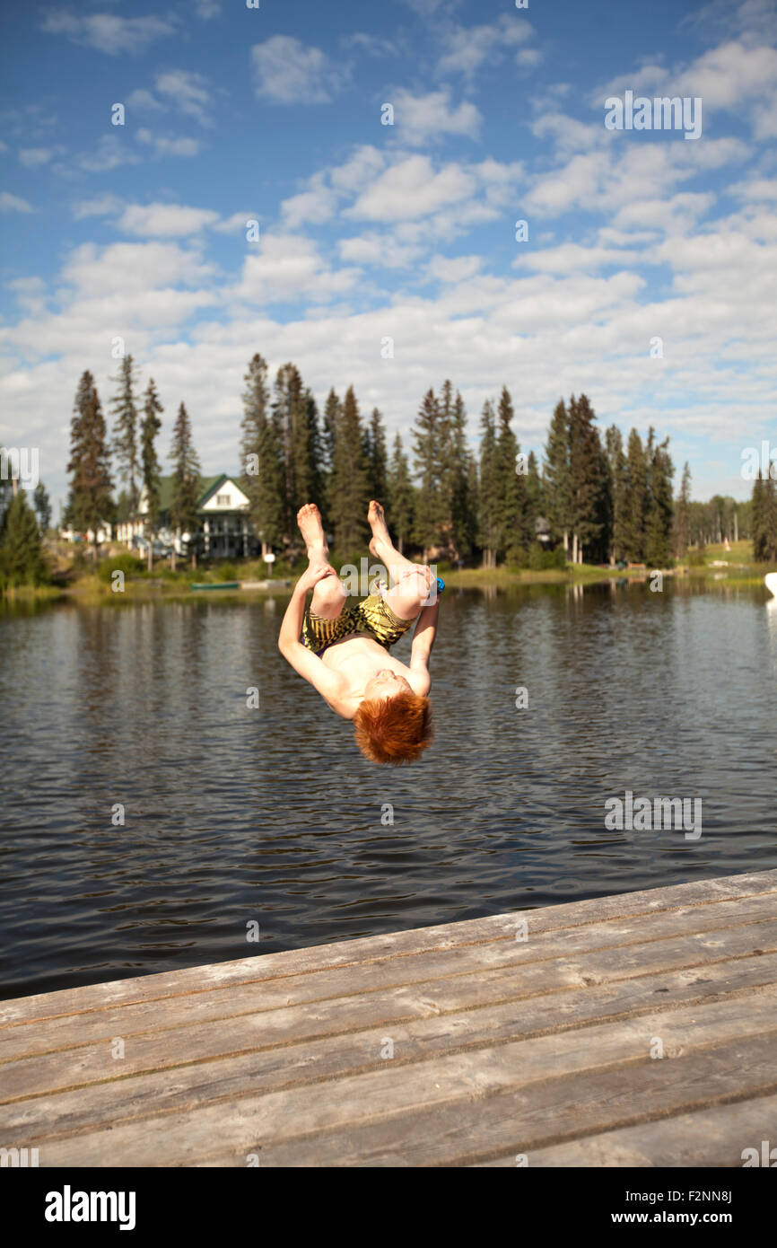 Young boy jumping dans le lac Banque D'Images