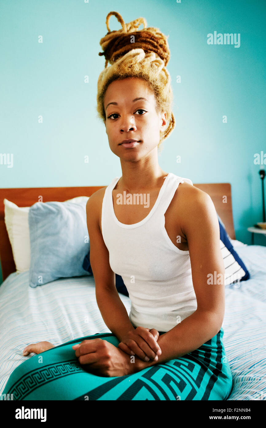 Black woman sitting on bed Banque D'Images