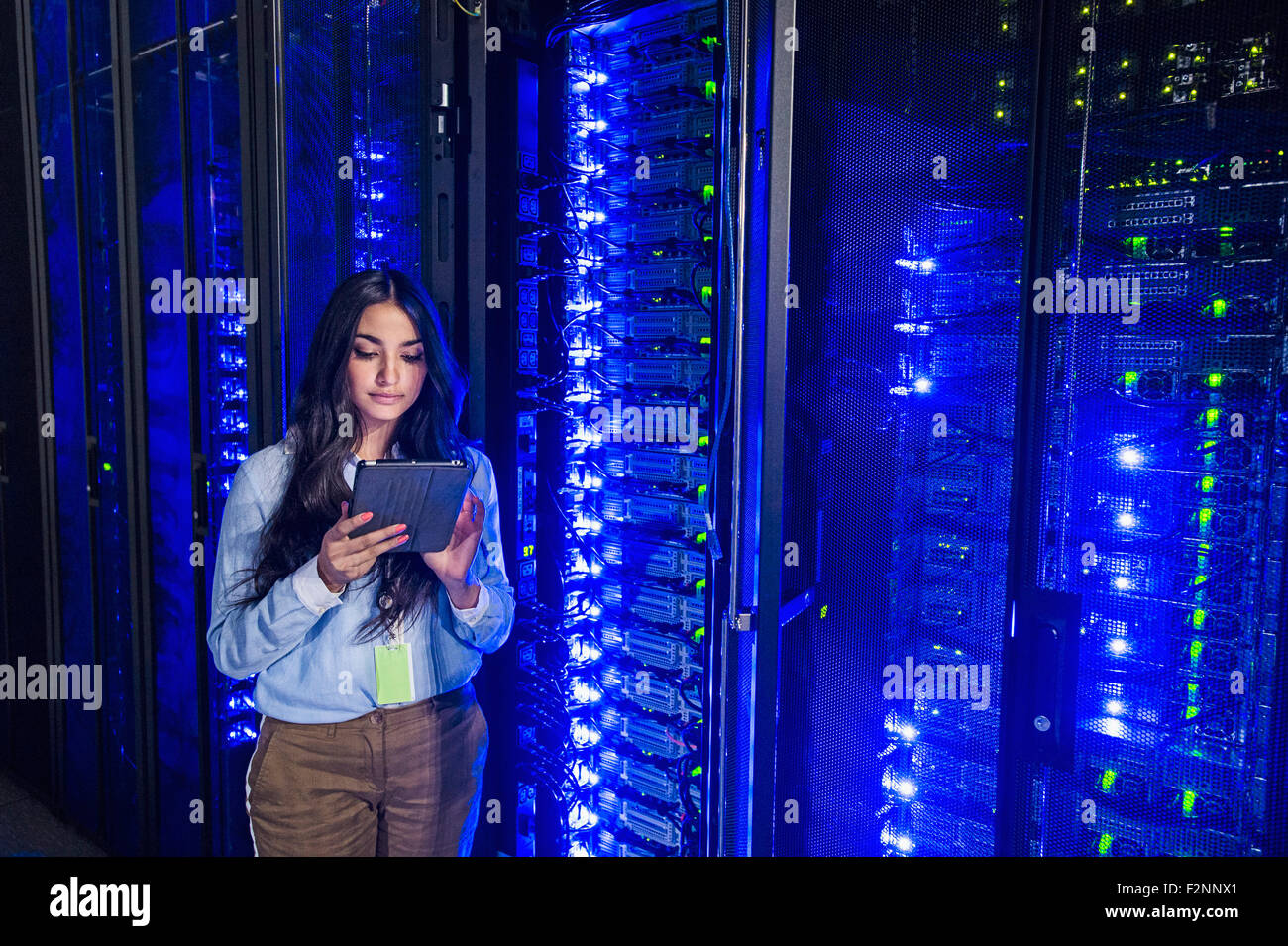 Mixed Race technician using digital tablet in server room Banque D'Images