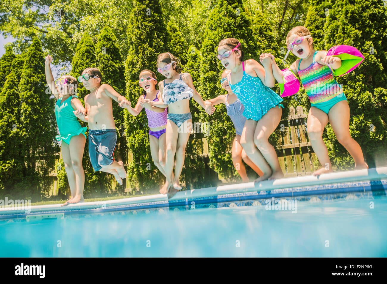 Les enfants de sauter dans une piscine Banque D'Images