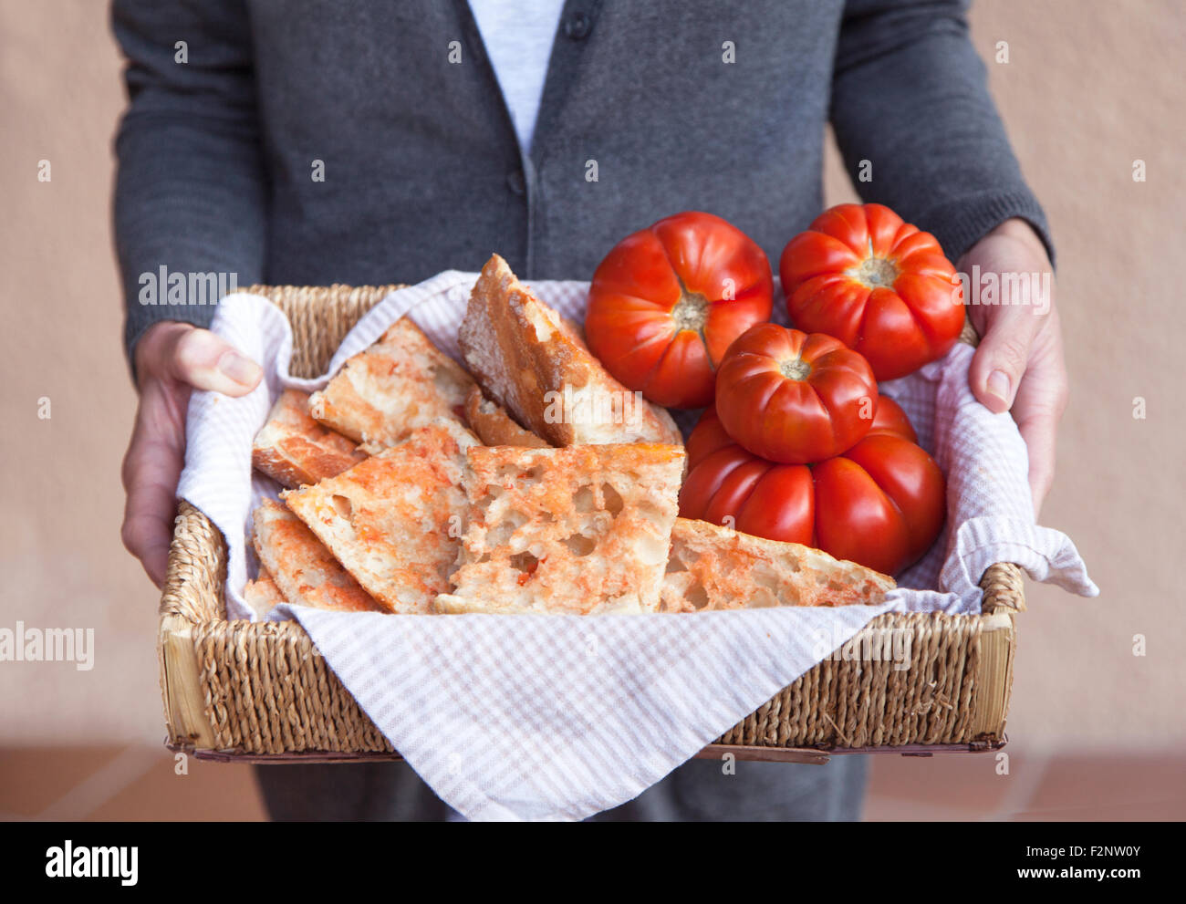 Jeune femme propose une cuisine catalane 'Pa amb tomàquet' (pain à la tomate) qui se compose de pain avec tomate frotté sur et Banque D'Images