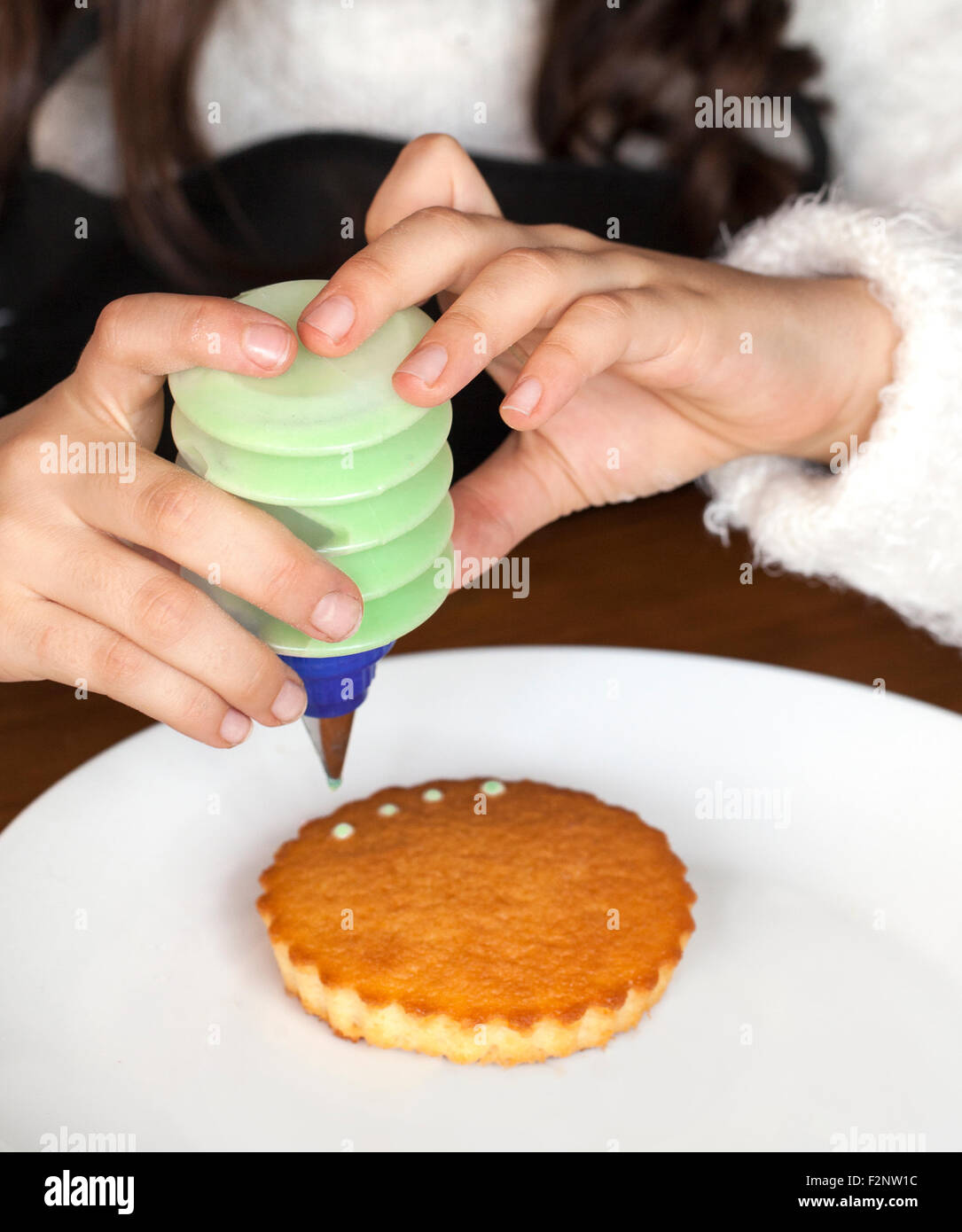 Mains d'un girl decorating cakes Banque D'Images