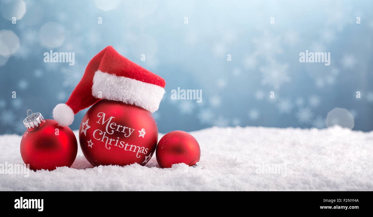 Boules de Noël dans le chapeau de Père Noël sur la neige. Banque D'Images