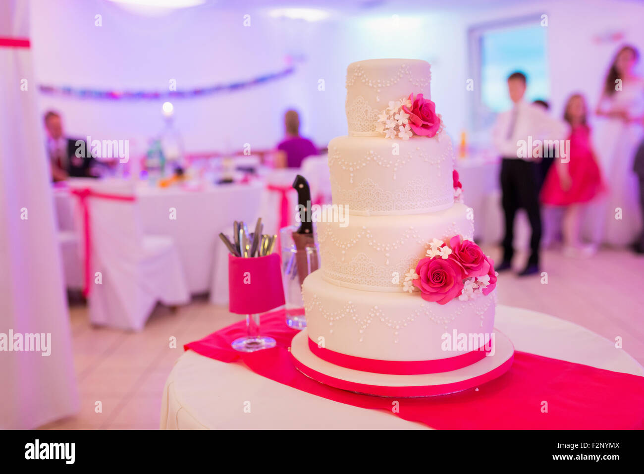 Un gâteau de mariage blanc multi de niveau mis sur une table Banque D'Images