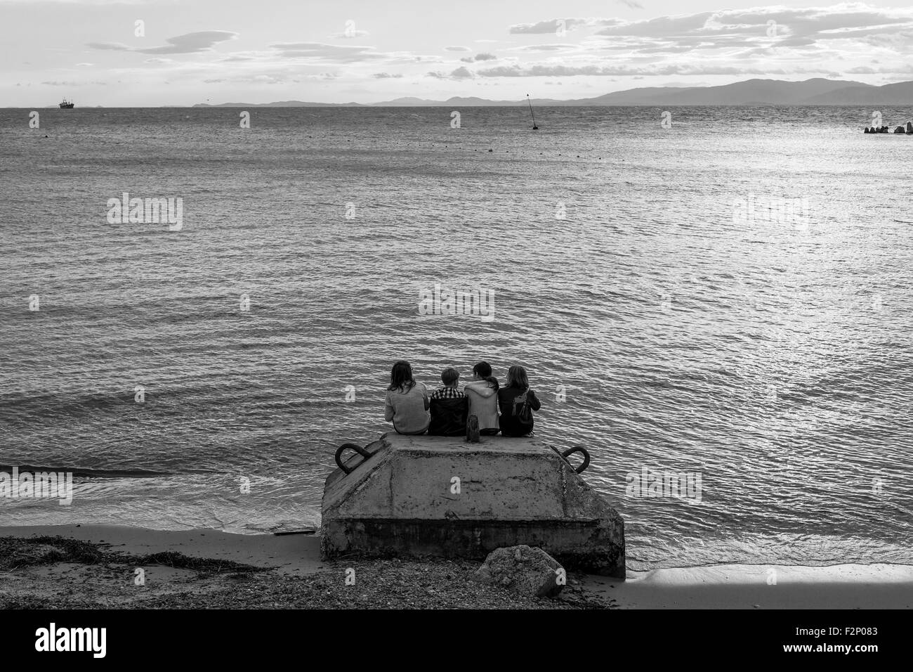 Amis à regarder le coucher du soleil sur la plage Banque D'Images