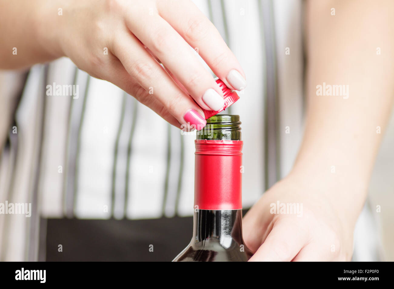 La main de femme se dévisse le bouchon à vis de bouteilles de vin rouge Banque D'Images