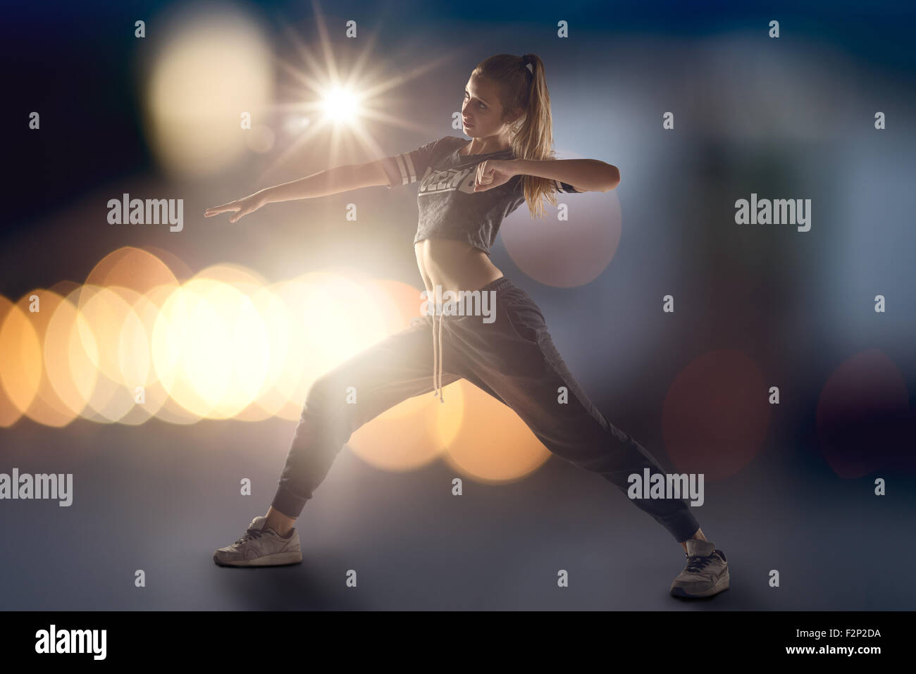 Tourné sur toute la longueur d'une jeune femme danseuse hip hop avec des lumières éclairant par derrière Banque D'Images