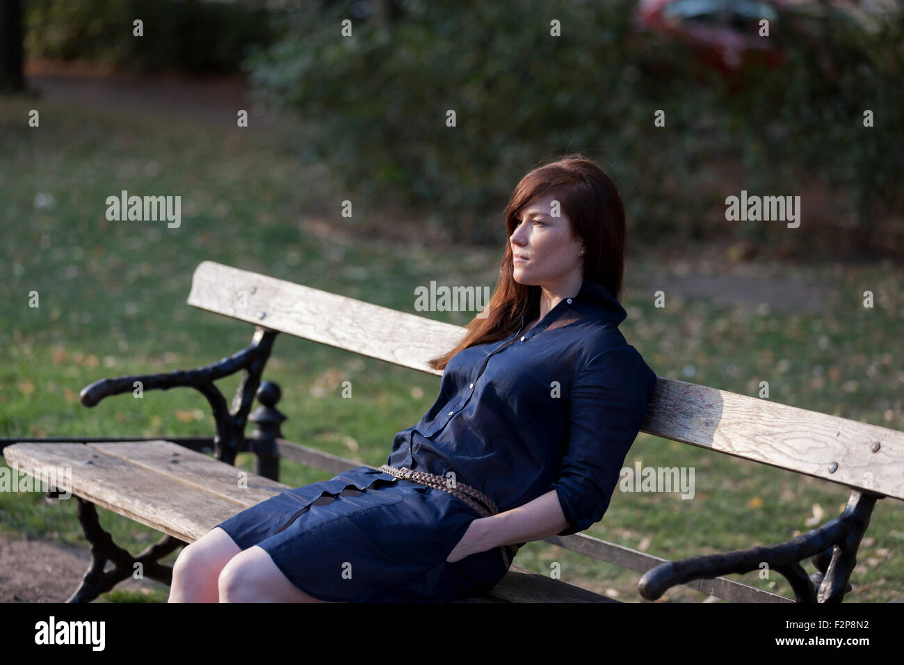 Portrait de femme assise sur un banc de parc Banque D'Images