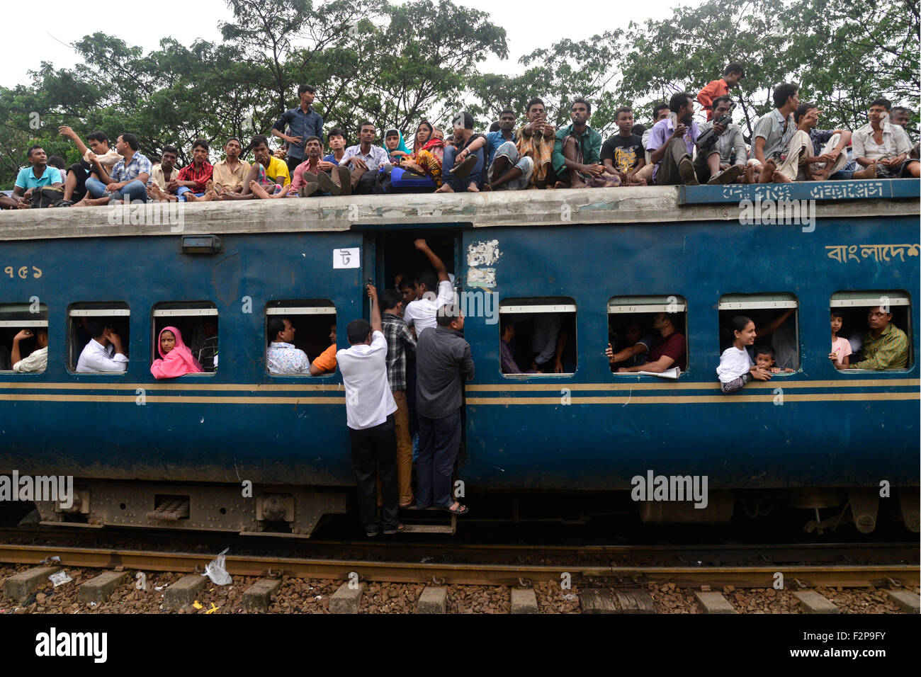 Dhaka, Bangladesh. 22 Septembre, 2015. Les musulmans du Bangladesh font de l'espace pour eux-mêmes sur le toit d'un train pour rentrer à la maison avant d'Eid-Ul-Adha comme d'autres attendent en gare à Dhaka. Le 22 septembre 2015, une foule de personnes faisant leur chemin pour rejoindre les familles d'accueil pour le prochain festival Eid-Ul-Adha a commencé à remplir les trains. Des millions de Bangladais voyagent à la maison pour célébrer la fête. Mamunur Rashid/crédit : Alamy Live News Banque D'Images