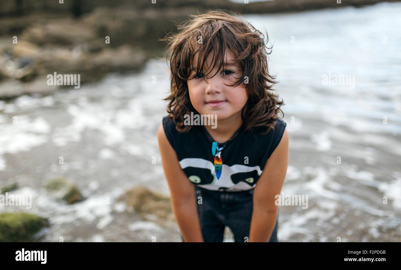L'Espagne, Gijon, portrait de petit garçon aux cheveux brun debout à front de mer Banque D'Images