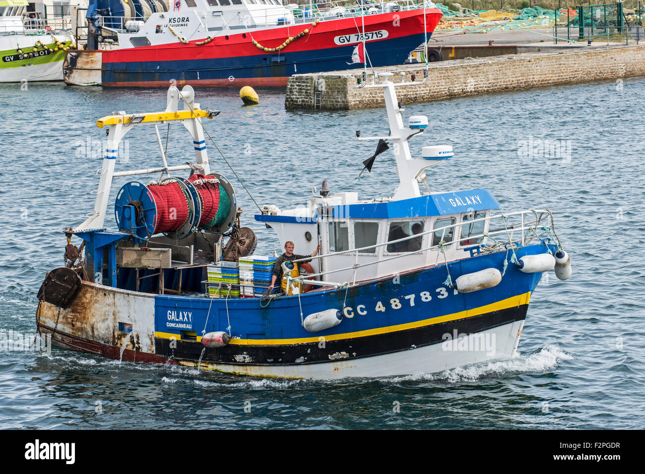 Bateau de pêche chalutier de quitter le port de Guilvinec, Finistère, Bretagne, France Banque D'Images