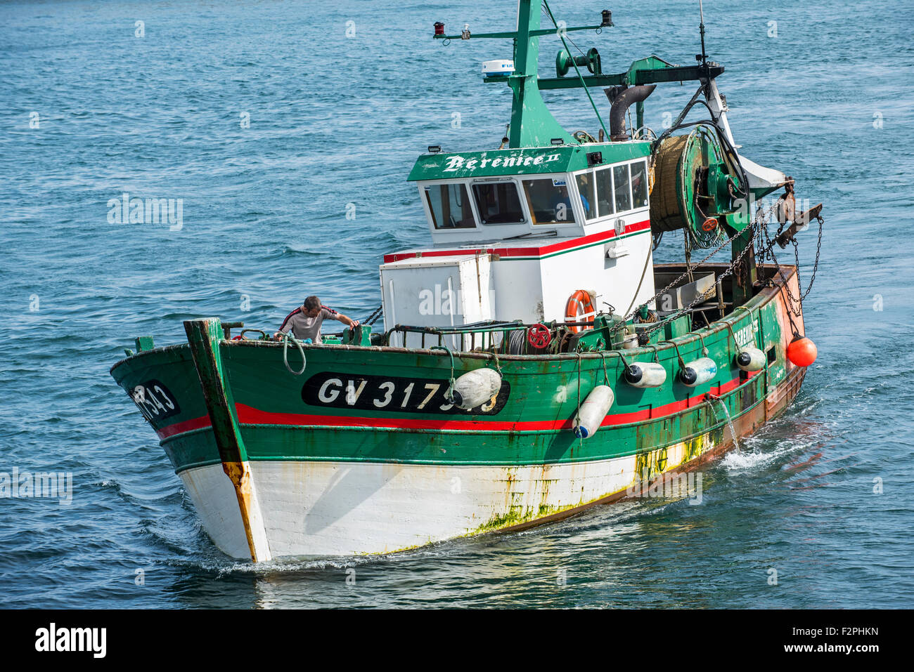 Pêcheur à bord du bateau de pêche chalutier en bois vert en mer, Bretagne, France Banque D'Images