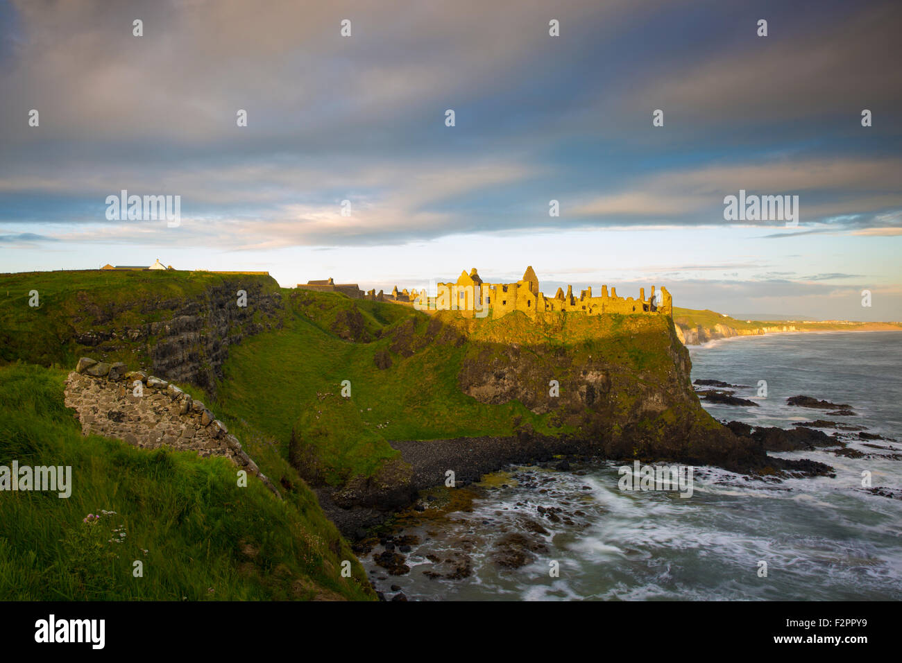 Le lever du soleil sur le château de Dunluce le long de la côte nord du comté d'Antrim, Irlande du Nord, Royaume-Uni Banque D'Images